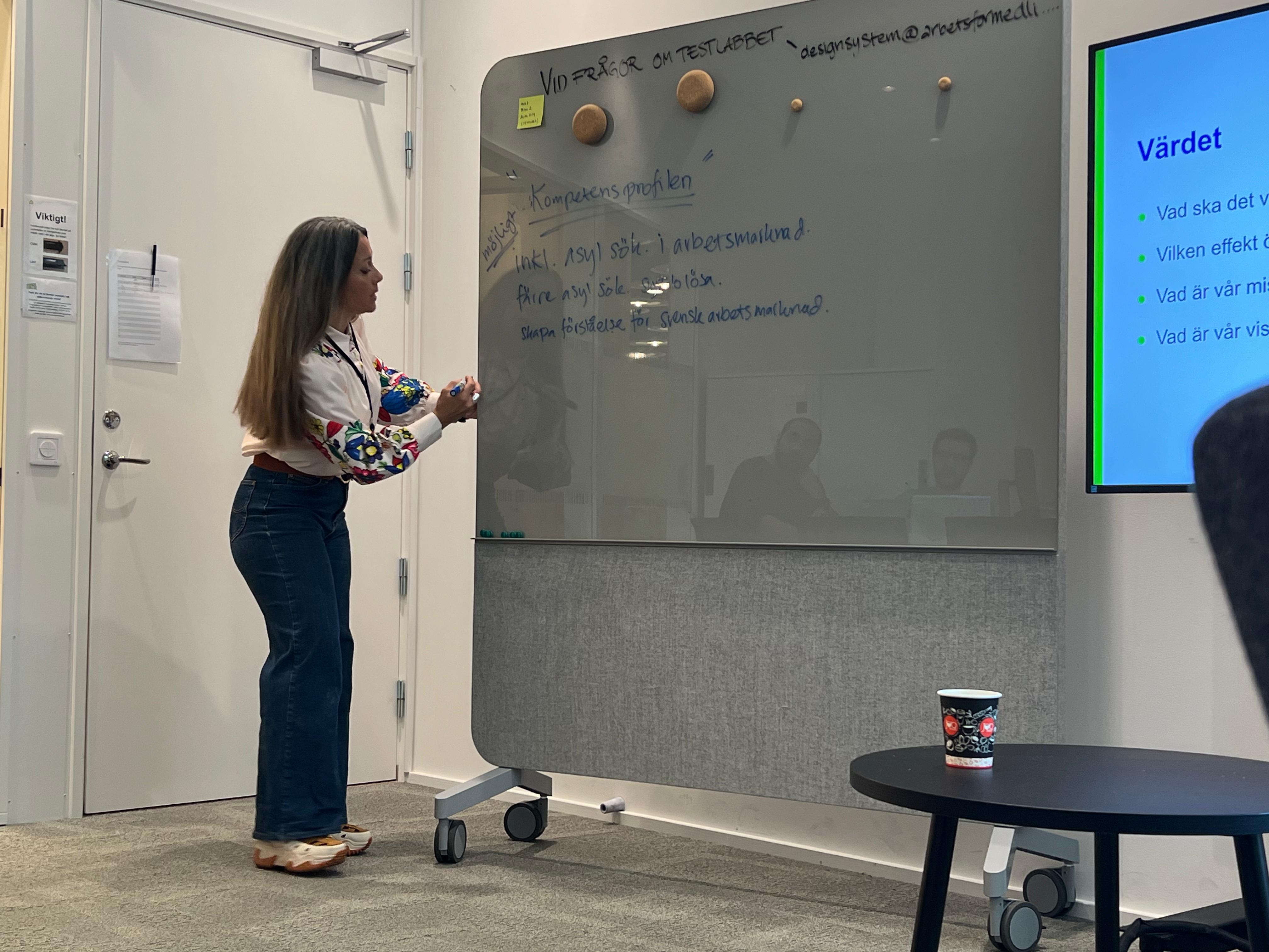 Elisabeth standing next to a whiteboard. 